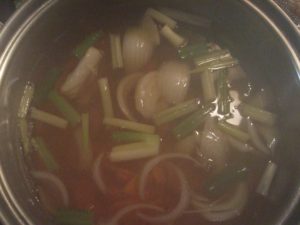 2.スープの素を作る。ここでは、スライスしたにんじん、玉ねぎ、長ネギ、刻みしょうが、コンソメを加えている。